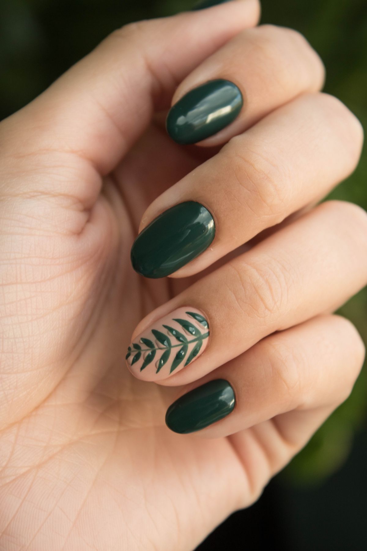 Green nail art design with leaf accent